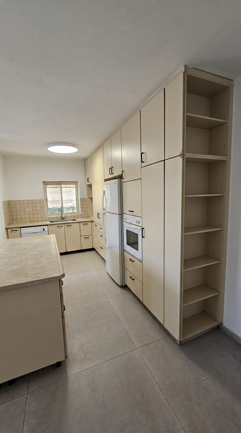 המטבח לפני השדרוג: חזיתות עץ כהות ומשטח עבודה שחוק